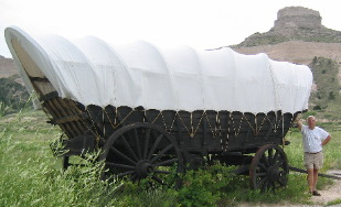 Mike standing next to a freight wagon on display at Scotts Bluff National Monument