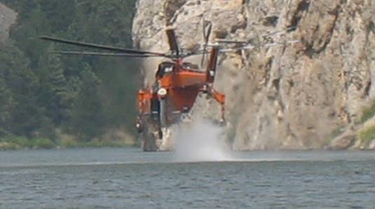 Fire fighting helicopter scooping water in Gates to the Mountains Wilderness
