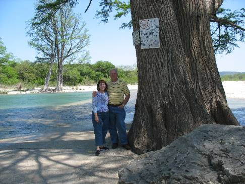 Mike & Joyce Hendris beside a giant cypress tree on the Rio Frio River near Concan, Texas