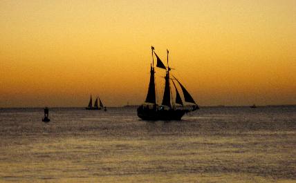 Sailboats out of Key West Bight Marina sailing past Sunset Pier in Key West