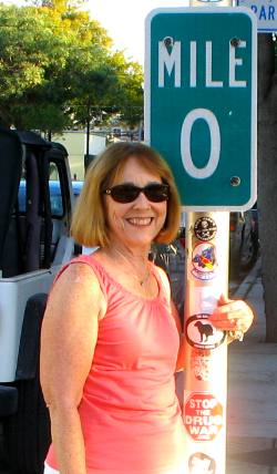 Joyce Hendrix posing with the US-1 mile marker 0 sign in Key West
