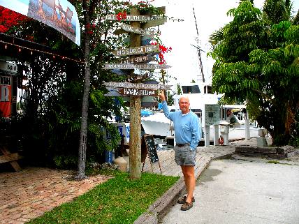 Mike posing in front of the direction post at Hogfish Grill on Stock Island 