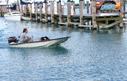 Small dinghy heading to the dinghy docks in the Historic Key West Seaport Harbor