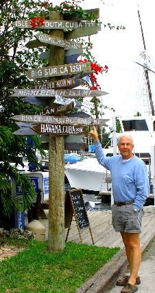 Mike Hendrix examining the direction marker in front of Hogfish Grill on Stock Island