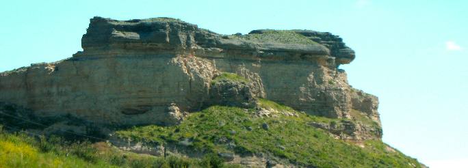 Volcanic ash protected by the harder (darker) caprock