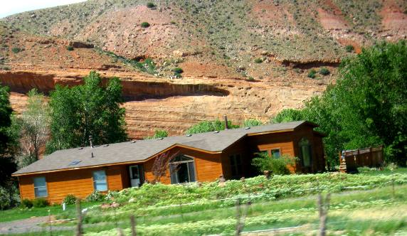 Ranch house at the base of an exposure of sedimentary rock