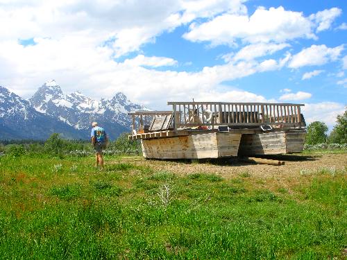 Mike walking alongside Menor's Ferry with the Teton Range in the background