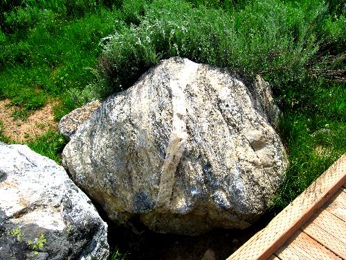Large boulder with dike running through it along Rockefeller Preserve walking trail