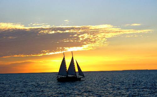 The old sailing schooner Appledore sailing into a beautiful Key West Sunset