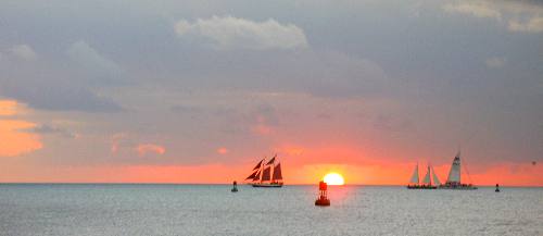 Fabulous Key West Sunset with three sunset cruise sailboats, the Jolly II Rover on the right with the red sails, the schooner Appledore in the center and one of the Fury catamarans on the right with the stripes in it's sail