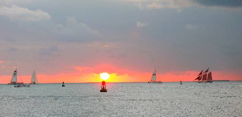 A beautiful Key West Sunset with the Jolly II Rover and her red sails