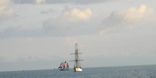 Jolly II Rover with the red sails and the Navy or Coast Guard sailing vessel docked in Key West
