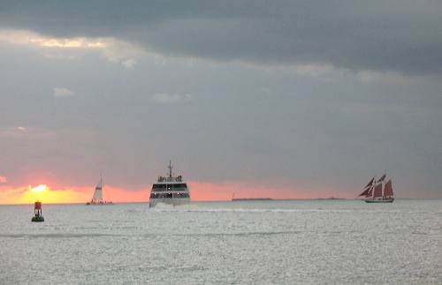 A beautiful Key West Sunset with the Key West Express and the red sails of the Jolly Rover