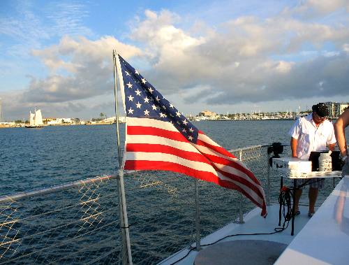 The DJ and American Flag flying off the stern of the Sunset Cruise boat Party Cat off Key West, Florida in February 2012