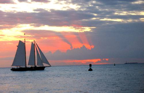 Key West sunset featuring rain clouds a red sky and the America 2 sailing schooner