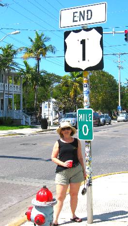 Joyce Hendrix  posing for a picture with the MILE 0 marker for US-1 on Whitehead Street in Key West, Florida