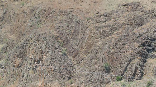 Geologic intrusion or dike that was causing the solid rock to contort into an anticline